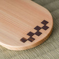 Close-up of the wooden chataku showing the inlaid dark-and-light checkered marquetry pattern