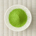 Bright green Uji-no-Mori matcha powder in a cream dish, viewed from above.