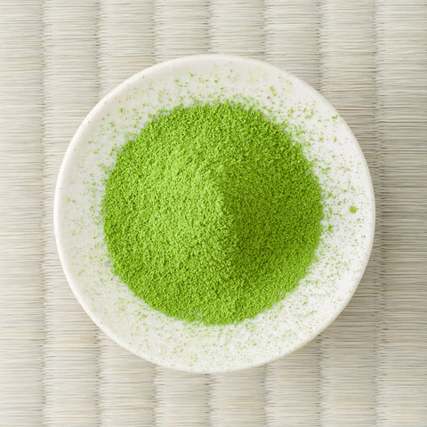 Bright green Uji-no-Mori matcha powder in a cream dish, viewed from above.