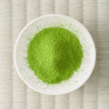 Bright green Uji-Hikari matcha powder in a cream dish, viewed from above.