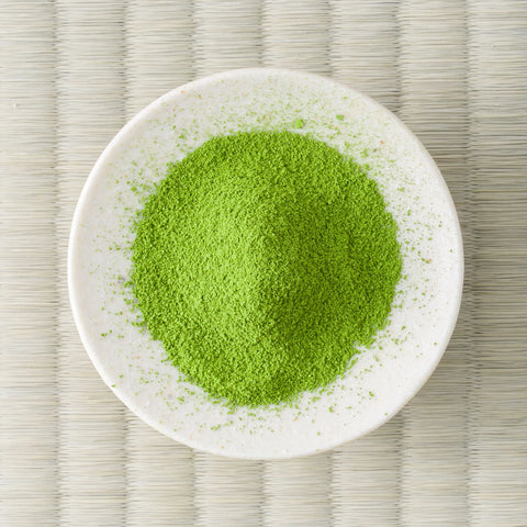 Bright green Uji-Hikari matcha powder in a cream dish, viewed from above.