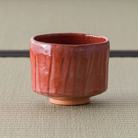 Aka-raku Komachi red raku matcha bowl, front view showing the vertical ribbed texture
