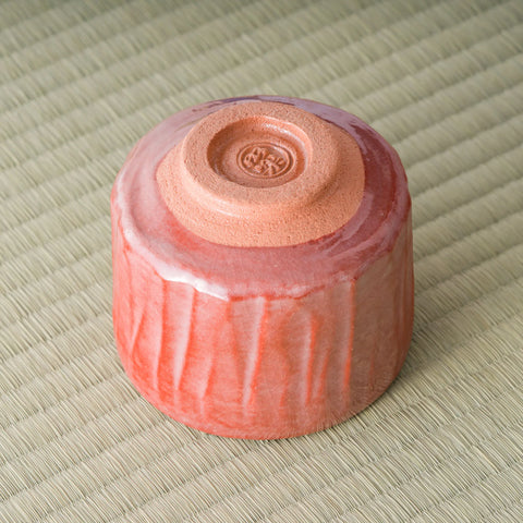 Aka-raku Komachi red raku matcha bowl, underside view showing the foot and spiral stamp