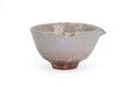 Cream-glazed Hagi spouted chawan with reddish blush, angled to show the spout - three-quarter view