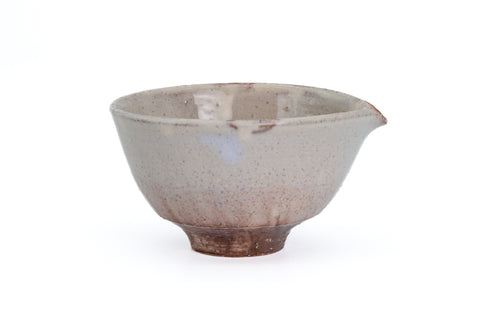 Cream-glazed Hagi spouted chawan with reddish blush, angled to show the spout - three-quarter view