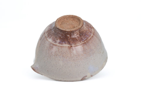 Inverted three-quarter of the beige Hagi spouted bowl showing the foot ring and glazed underbody