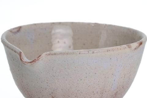 Side profile close-up of the beige Hagi-yaki spouted chawan with a bluish blush in the cream glaze