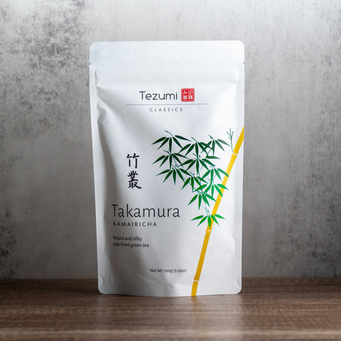 Tezumi Classics Takamura Kamairicha tea package on a wooden surface with a gray background