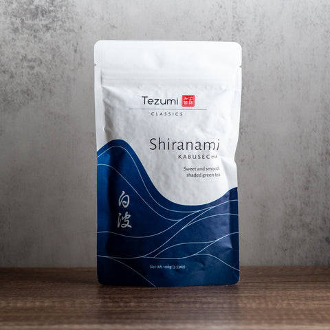 Tezumi Shiranami Kabusecha tea package on a wooden surface with a gray background