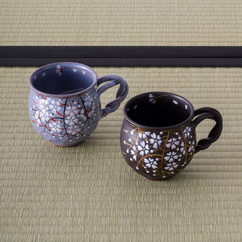 Two ceramic mugs with floral patterns on tatami mats