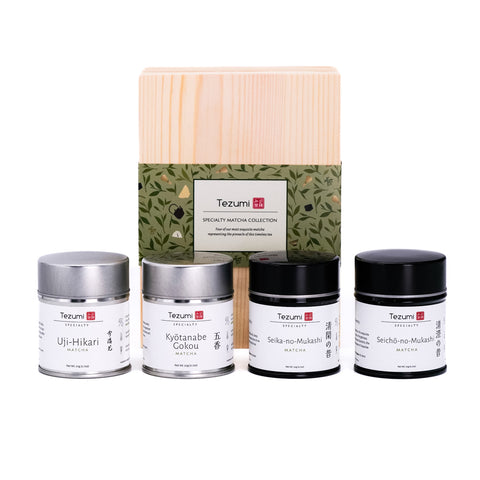 Tezumi specialty matcha collection with four tea tins and a wooden box on a white background