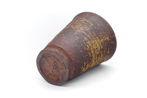 The cup laid on its side showing the foot and ribbed body.