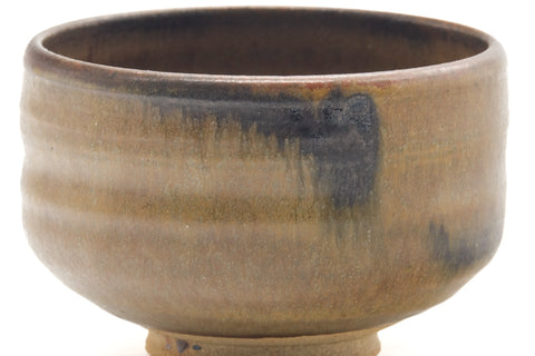 Close side view of the chawan showing vertical glaze drips and mottled shading.