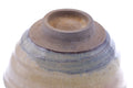 Underside of the chawan showing the unglazed clay foot ring and concentric grey-and-amber glaze bands.
