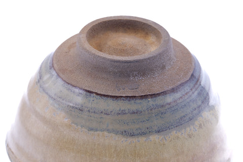 Underside of the chawan showing the unglazed clay foot ring and concentric grey-and-amber glaze bands.