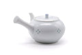 Angled view of the white teapot showing the body, handle and floral motif.
