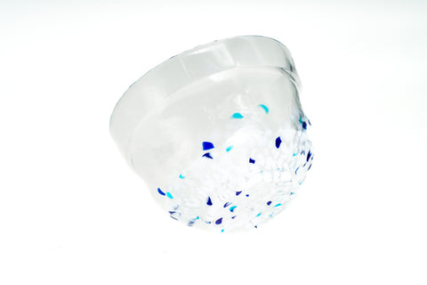 Clear glass matcha bowl with blue specks on a white background