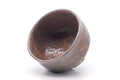 The chawan tipped to reveal its glazed interior and rim.