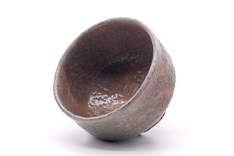 The chawan tipped to reveal its glazed interior and rim.