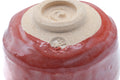 Close-up of the underside showing the spiral foot and red glaze.