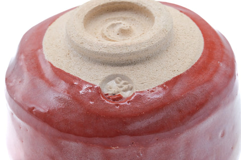 Close-up of the underside showing the spiral foot and red glaze.