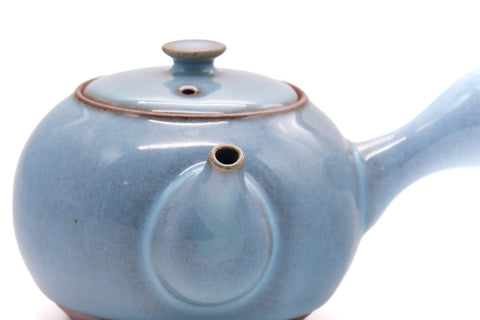 Three-quarter closeup of the kyusu showing the lid knob and glazed body.