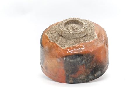 Underside of the raku bowl tilted to show the foot.