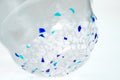 Clear glass matcha bowl with blue specks on a white background