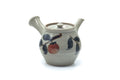 Grey ceramic Japanese kyusu teapot with painted red and blue fruit motifs, front three-quarter view with the spout to the left and the side handle to the right.