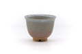 Front view of a Hagi-yaki yunomi with a grey-and-pink glaze and a flared rim.