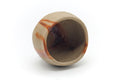 Yunomi tilted to show the interior and rim, with hidasuki streaks across the surface.