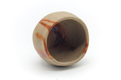 Yunomi tilted to show the interior and rim, with hidasuki streaks across the surface.