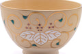 Close-up of a blue-and-purple painted motif on the ochre glaze.