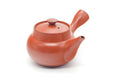 Red shudei Tokoname kyusu with a side handle and collared lid, shown from a three-quarter angle.