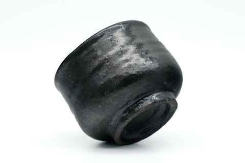 Black ceramic cup on a white background - tilted underside