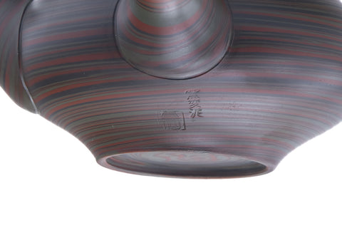 Closeup of the body detailing the green, red and black nerikomi marbled clay