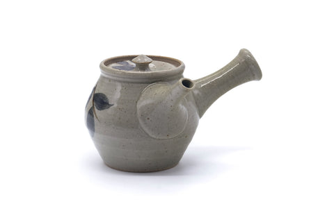 Side view of the grey kyusu with the lid on and the spout pointing right, showing the painted fruit decoration.
