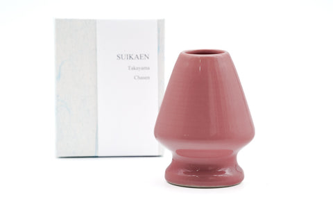 A pink Seto-yaki chasen kusenaoshi displayed alongside its packaging, designed for shaping or restoring the bamboo tines of a matcha whisk.