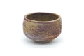 Mottled brown wabi-sabi yunomi, front view with a dimpled purple-brown wood-ash glaze.