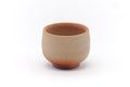 Angled view of the Bizen guinomi, showing the orange hidasuki scorch marks crossing the unglazed clay.