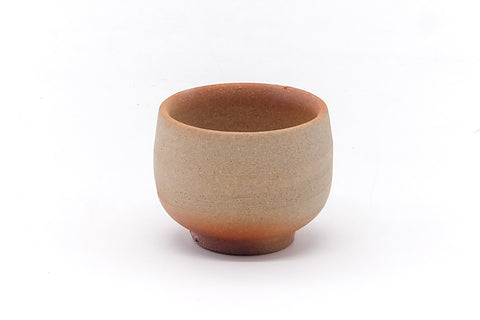 Angled view of the Bizen guinomi, showing the orange hidasuki scorch marks crossing the unglazed clay.