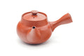 View showing the side handle, lid, and spout of the red teapot.