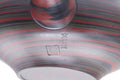 Close-up of the marbled nerikomi clay surface with reddish and dark bands.