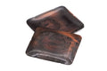 The square copper sharing plates arranged at an angle, revealing the indented trim and floral motif.