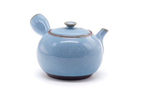 Opposite side view of the blue teapot showing the handle and spout.