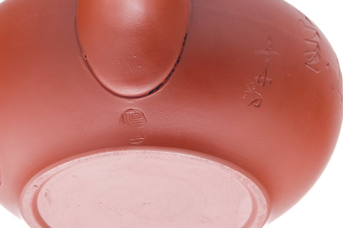 Closeup of the body detailing the engraved calligraphy in the red shudei clay