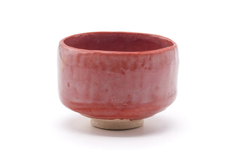 Front view showing the salmon-red raku glaze with mottled dark areas.