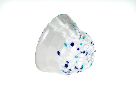 Clear glass teacup with white and blue speckles on a white background