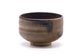 Japanese matcha bowl (chawan), three-quarter front view, brown-to-grey mottled glaze with a dark interior.