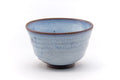 Sky-blue milky-glazed Agano-yaki chawan, front view with a warm brown patch.